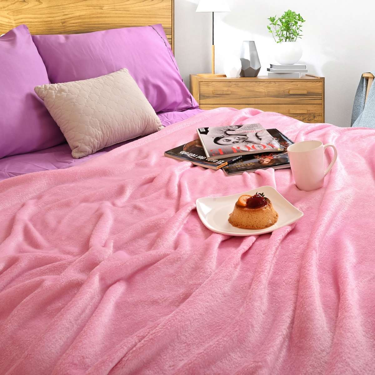 Cobija de flanel color rosa tamaño matrimonial tendida sobre una cama