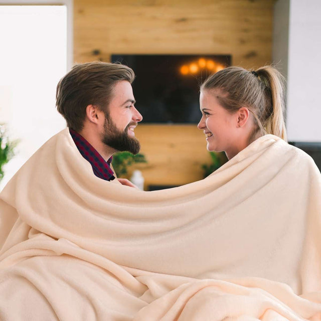 hombre y mujer sonriendose envueltos en una cobija hueso matrimonial