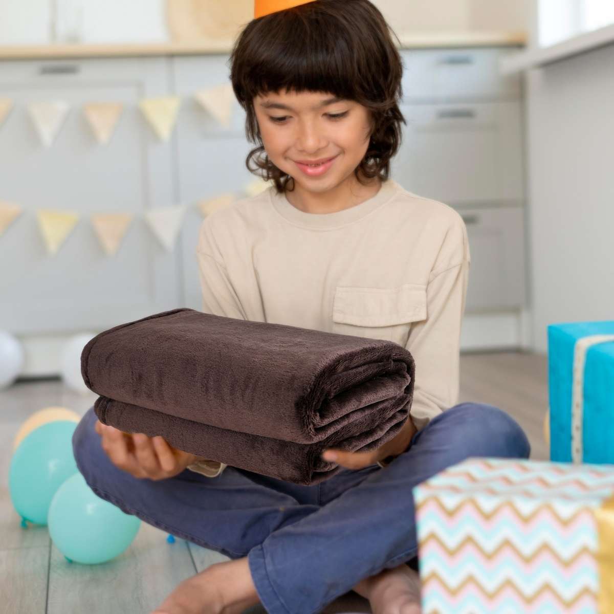 Mujer emocionada recibiendo de regalo una cobija de color café, disfrutando del gesto cálido y reconfortante. queen size