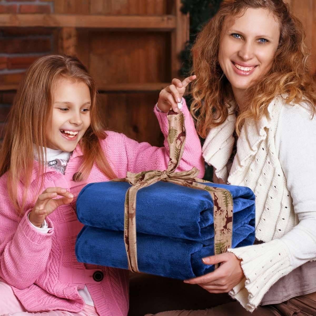 Mamá regalando a su hija una cobija color marino como gesto de amor y calidez