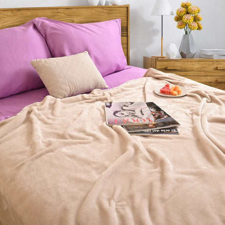 Cobija de flanel color arena tamaño individual tendida sobre una cama