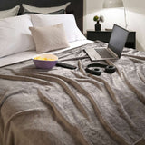 Cobija de flanel color gris claro tamaño individual tendida sobre una cama