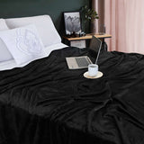 Cobija de flanel color negro tamaño individual tendida sobre una cama