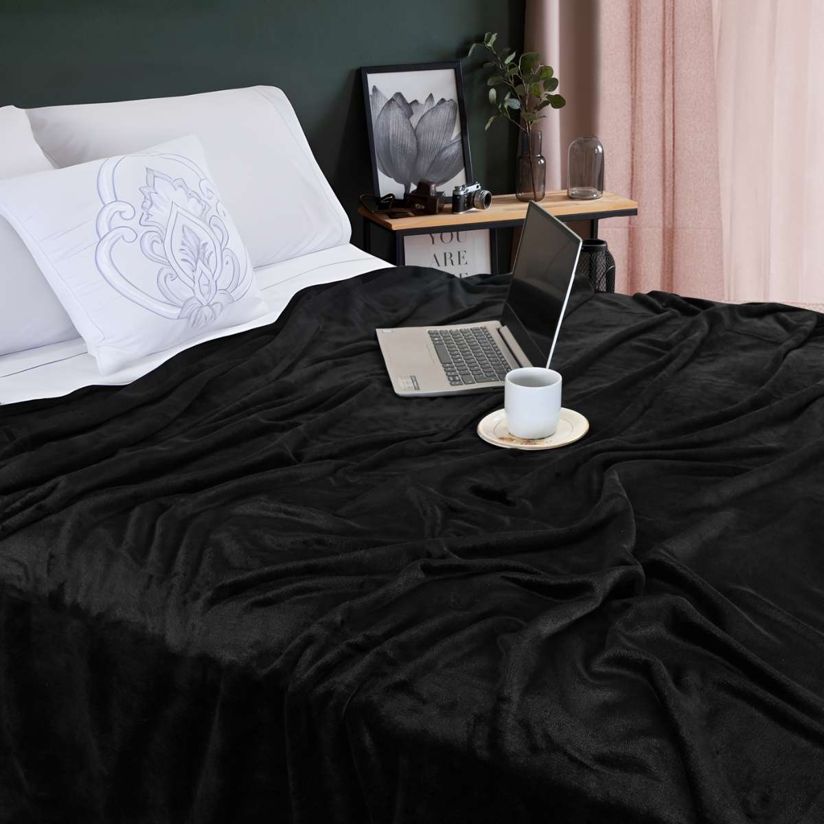 Cobija de flanel color negro tamaño king size  tendida sobre una cama