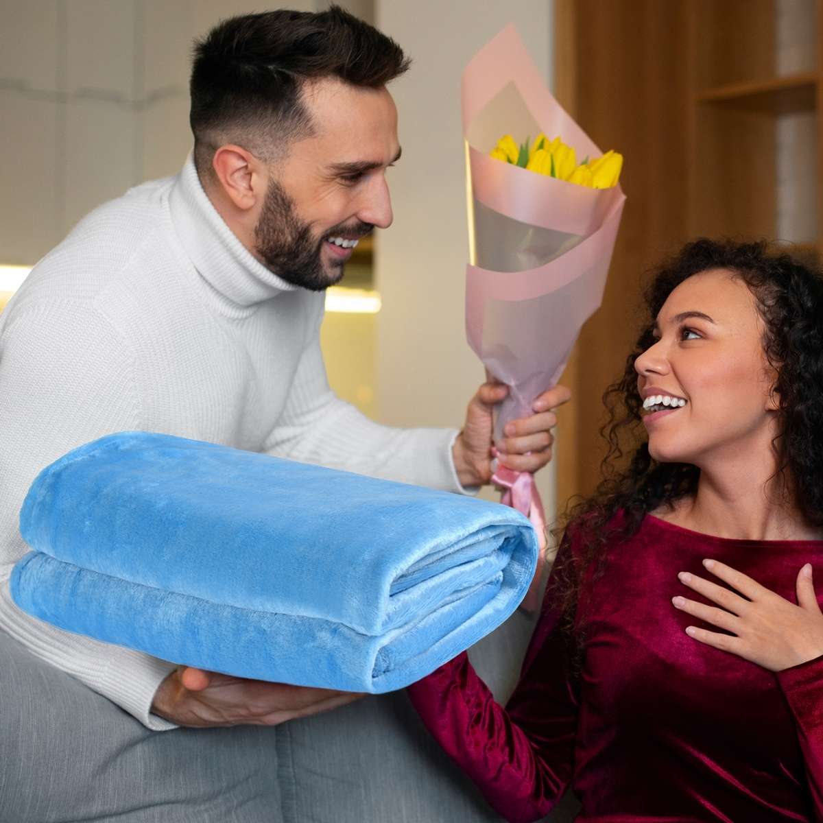 hombre regalando a mujer una cobija matrimonial azul turqueza