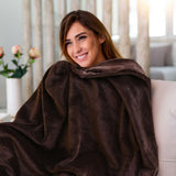 Mujer disfrutando de una cobija de flanel color café tamaño matrimonial  en un sillón